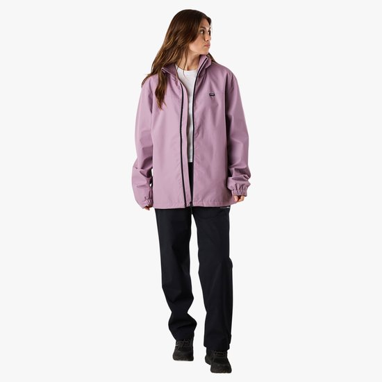 Vrouw in paarse windjack met zwarte rits, wit T-shirt en zwarte broek.