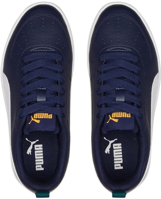 Bovenkant van donkerblauwe sneakers met witte Puma strepen en gele Puma logo's op de zolen.