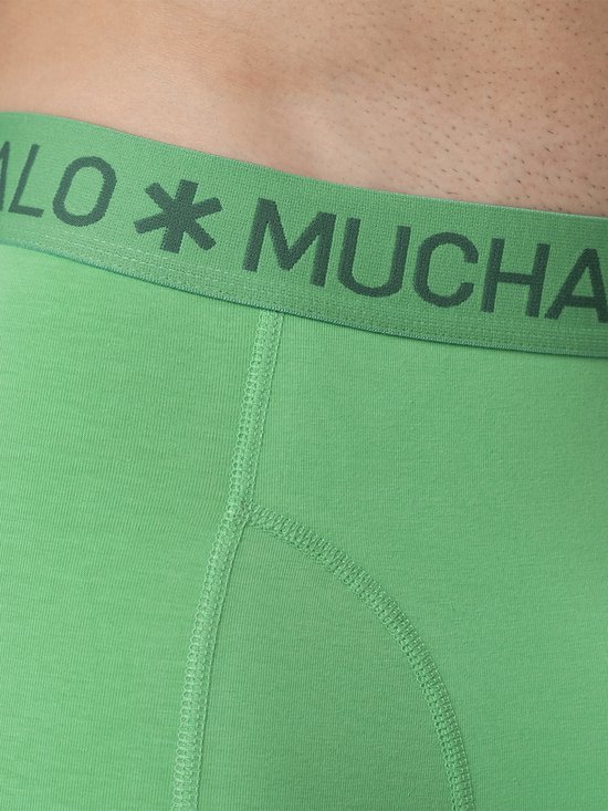 Detail van een felgroene boxslip met 'MUCHACHOMALO' logo-band en stiksels.
