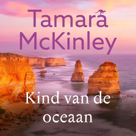 Boek 'Kind van de oceaan' met de tekst 'Tamara McKinley' op een achtergrond van rotsformaties aan zee bij zonsondergang.