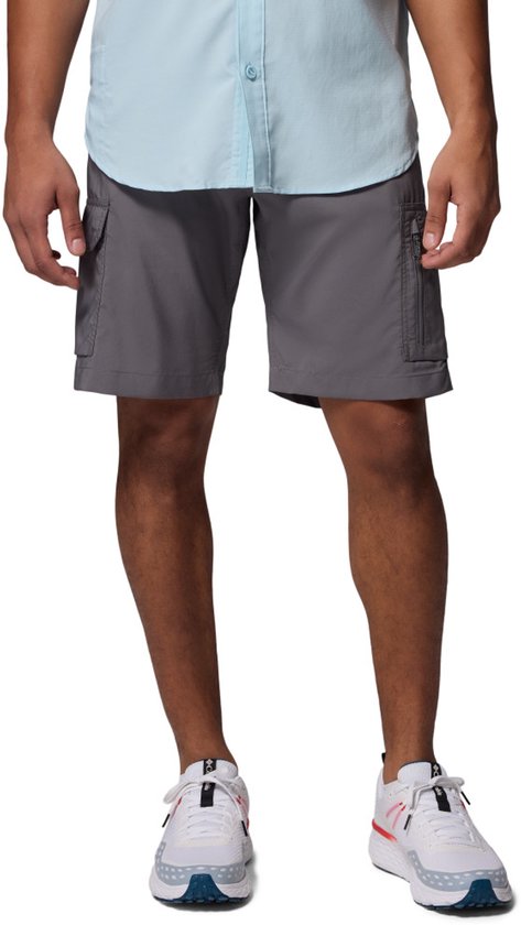 Man draagt grijze cargo shorts met opgestikte zakken, een lichtblauwe blouse en witte sneakers.