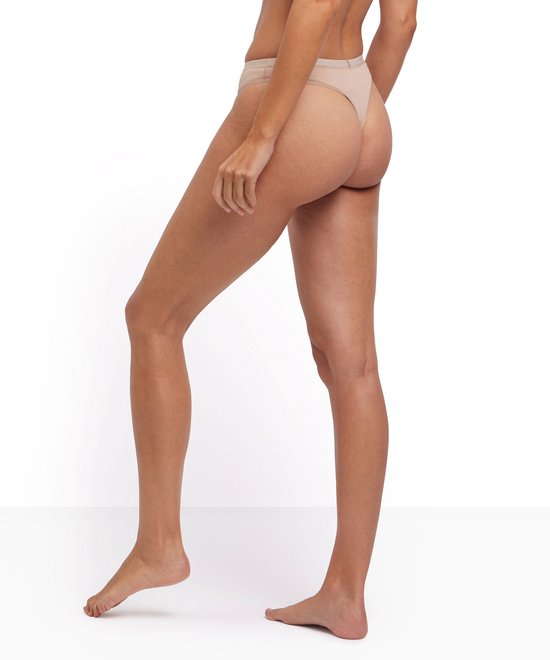 Achterkant van een model in beige Falke slipje met logo band.