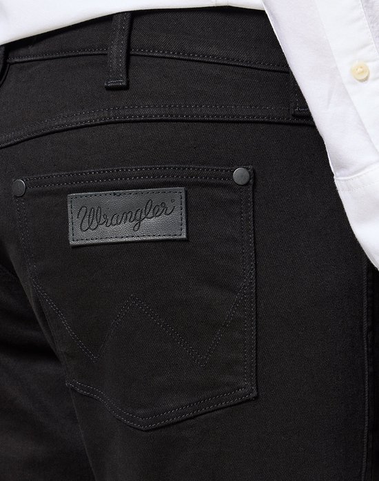 Zwarte jeans met Wrangler logo patch op de achterzak.
