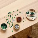 Table en bois avec du bambou LEGO, des feuilles, des pierres et des pots.