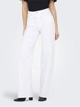 Vrouw in zwarte top en witte wide-leg jeans.