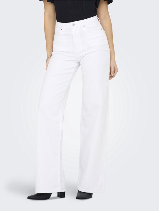 Vrouw in zwarte top en witte wide-leg jeans.