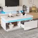 Witte hoogglans salontafel met blauwe LED-verlichting, open vakken en een gedeeltelijk geopende lade met opbergruimte.