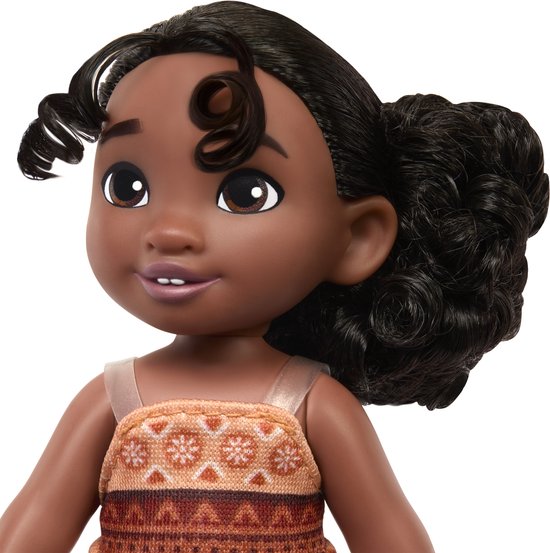 Close-up van baby Moana pop met krullend haar en een oranje en bruin jurkje.