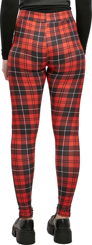 Achterkant van een vrouw in een rode ruit legging en zwarte loafers.