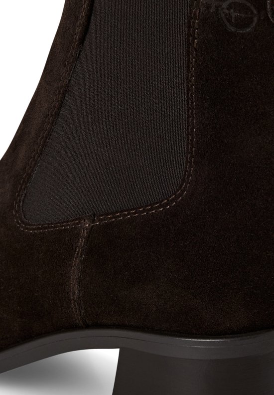 Detail van de elastische zijkant van een bruine suède chelsea laars met stiksels en Tamaris logo.
