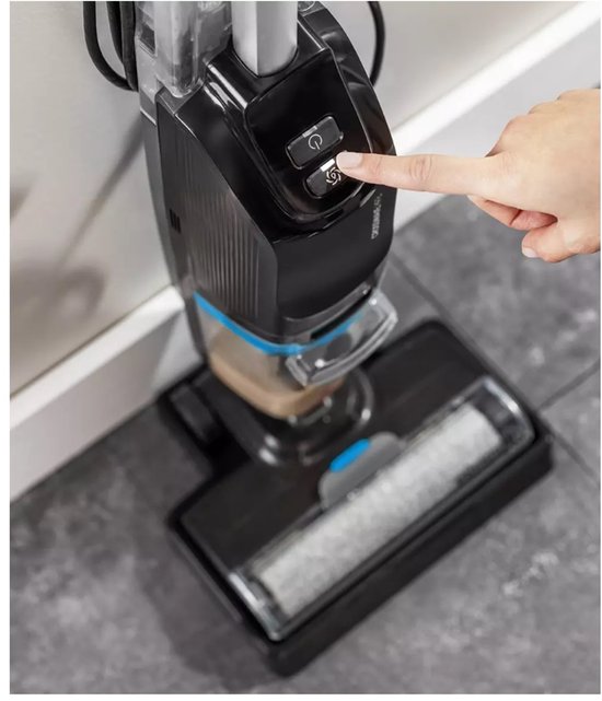 Een vingertop drukt op de aan/uit-knop van de zwarte BISSELL CrossWave vloerreiniger.
