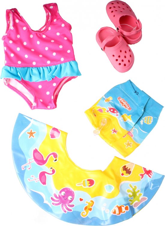 Roze badpak met stippen en blauwe ruches, armpjes, roze crocs en blauwe zwemspatbord.