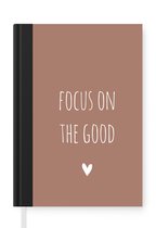 Notitieboek - Schrijfboek - Engelse quote "Focus on the good" met een hartje op een bruine achtergrond - Notitieboekje klein - A5 formaat - Schrijfblok