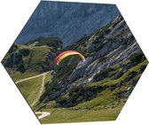 WallClassics - Dibond Hexagon - Paraglidend door de Bergen en Natuur - 70x60.9 cm Foto op Hexagon (Met Ophangsysteem)