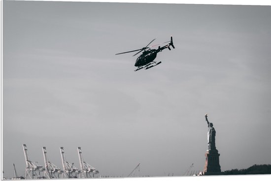 WallClassics - PVC Schuimplaat - Helikopter zwevend boven Vrijheidsbeeld in New York - 90x60 cm Foto op PVC Schuimplaat (Met Ophangsysteem)