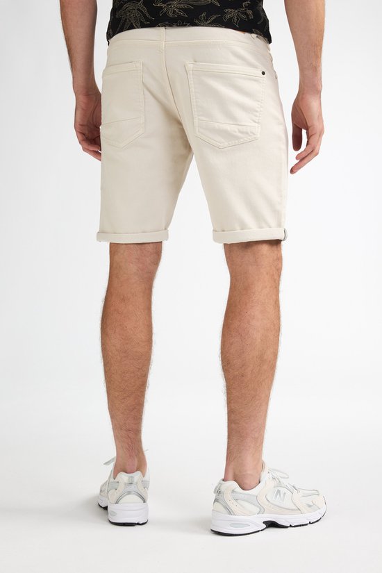 Achterkant van een beige korte broek met opgerolde zoom.