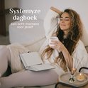 Vrouw ontspannen op bank met een Systemyze dagboek en kopje koffie