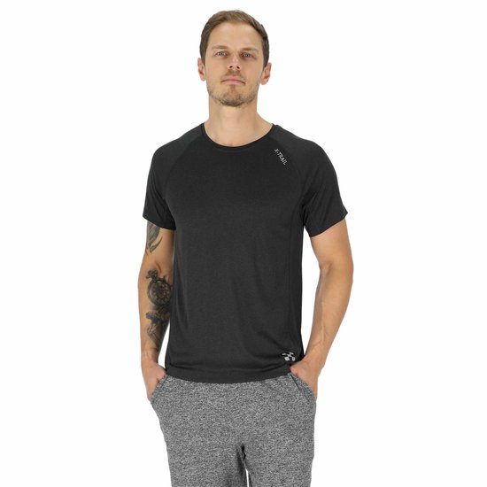 Homme tatoué portant un t-shirt X-Trail gris foncé et un pantalon de survêtement gris.