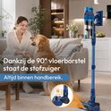 Vrouw met hond op de bank, blauwe steelstofzuiger met 90° vloerborstel in de buurt.