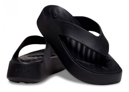 Paire de tongs compensées noires Crocs, l'une avec le logo Crocs, l'autre sur le côté.