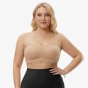 Model met blote schouders draagt een huidkleurige strapless push-up bh met uitneembare pads.