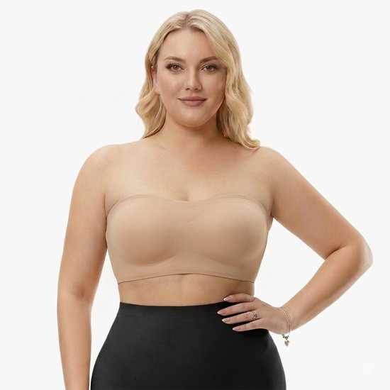 Model met blote schouders draagt een huidkleurige strapless push-up bh met uitneembare pads.