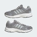 Grijze Adidas sneakers met witte veters, lichtgrijze strepen en witte zolen.