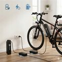 Zwarte elektrische mountainbike naast een opladende accu met pictogrammen voor batterij en bliksem.
