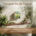 Zeri geluidshuisje met bloemenveld print hangt aan de muur boven een toilet.