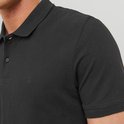 Close-up van een donkere polo met geborduurd logo op de borst