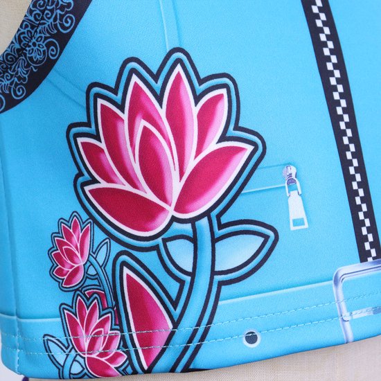 Blauw crop top met roze bloemenprint en ritsdetail.