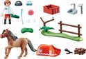Un set de jouets Playmobil avec un cheval marron, un garçon, une clôture, un panier et d'autres accessoires.