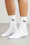 Man met witte PUMA crew sokken met zwarte Puma logo's.