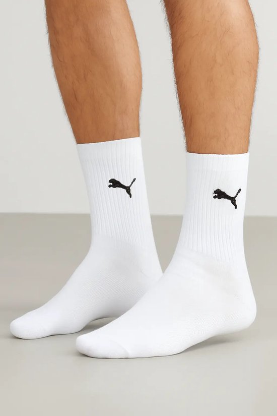 Man met witte PUMA crew sokken met zwarte Puma logo's.