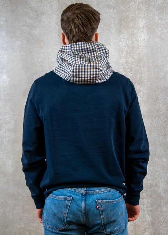 Man draagt donkerblauwe hoodie met geblokte kraag, rug zichtbaar.