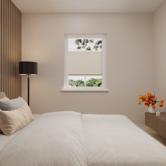 Une chambre avec un store plissé couleur sable, un lit et une lampe sur pied.
