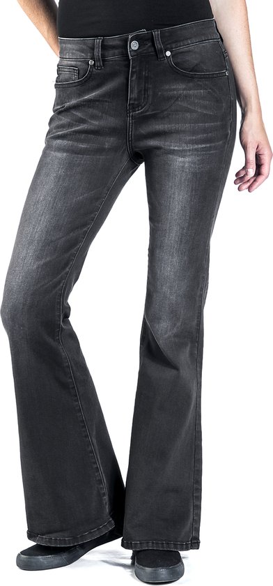 Model draagt een donkergrijze flared jeans met lichte wassing en steekzakken.