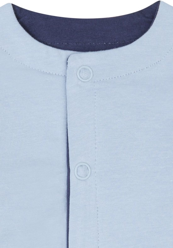 Detail van de sluiting van een lichtblauw vestje met donkerblauwe boord en knopen.