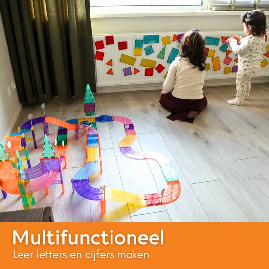 Kinderen spelen met magnetische tegels en een racebaan. Multifunctioneel. Leer letters en cijfers maken.