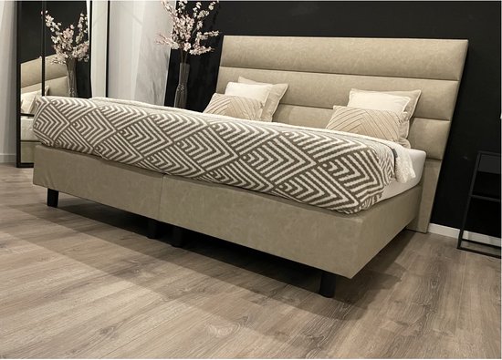 Beige boxspring 180x200cm met geometrisch patroon deken in beige en grijs. Hoge, gestoffeerde hoofdbord.