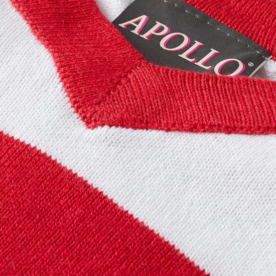 Detail van een gebreide trui met rode en witte strepen en het Apollo logo.