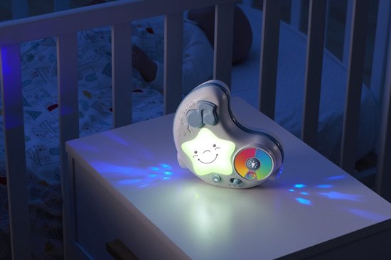 Baby nachtlampje op een nachtkastje, met sterrenprojectie op de muur. Het lampje heeft een lachende ster en een kleurenschijf.