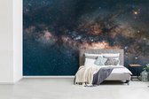 Behang - Fotobehang De Melkweg bij een blauwkleurige lucht - Breedte 400 cm x hoogte 240 cm