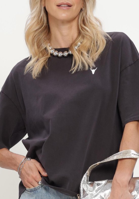 Model draagt een donkergrijs T-shirt met witte stierkop en zilveren ketting.