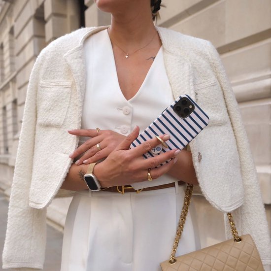 Persoon in witte outfit houdt een marineblauw gestreept Burga iPhone hoesje vast met een ringhouder.