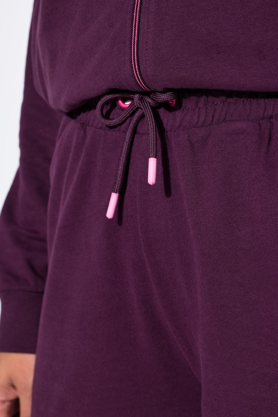 Detail van het trekkoord van een donkerpaarse joggingbroek.