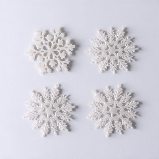 Vier witte, kunststof sneeuwvlokhangers met een glinsterende textuur op een witte achtergrond.