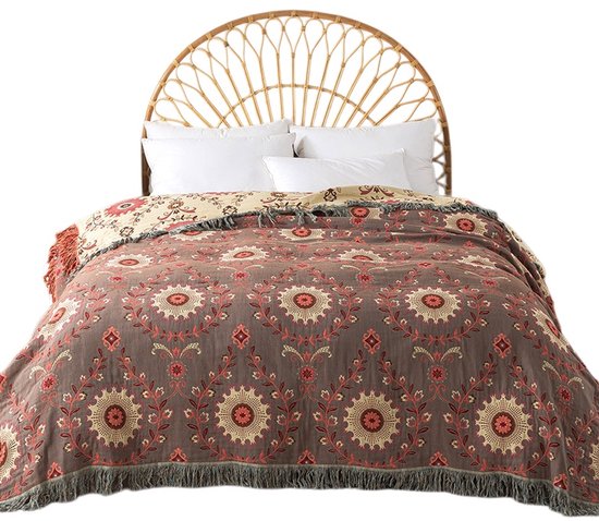 Bruine plaid met een bohemien-stijl patroon van rode en beige bloemen. De plaid heeft franjes aan de zijkanten.