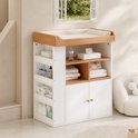 Witte commode met houten blad en aankleedkussen, zijwaartse opbergvakken en kastdeurtjes in een lichte kamer.