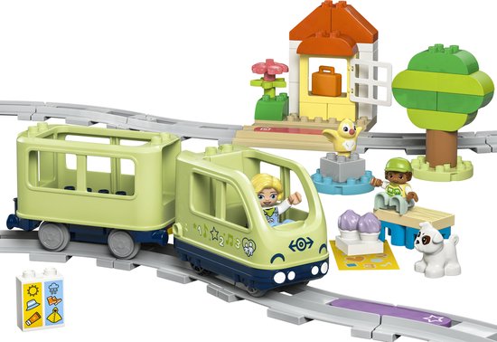 LEGO DUPLO treinset met rails, lichtgroene locomotief en wagon, twee figuren, een hondje en een klein station.